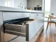 Explore a sophisticated metal drawer system featuring organized kitchen utensils in a modern kitchen.