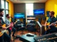 Musicians actively engaged in music pitching in a vibrant recording studio setting.