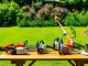 Stihl Kettensägen und Gartengeräte in einem lebhaften Garten präsentieren sich vor einer blühenden Kulisse.
