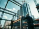 Workers assembling structural steel construction for a skyscraper in an urban environment.