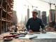 Expert New York City General Contractor overseeing a construction site with cranes and blueprints in focus.
