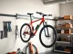 Showcasing a stylish bicycle wall hanger supporting a vibrant bike in a modern garage.